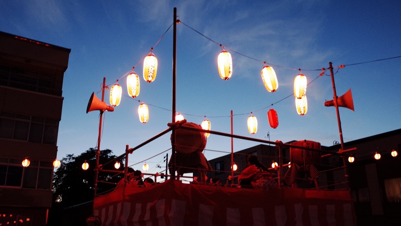 夕闇に包まれる盆踊りのやぐら